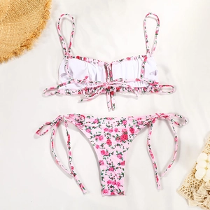 Flat lay of two-piece pink floral bikini with rose prints and side-tie swim bottoms