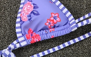 Close-up of floral bikini top with purple roses, stripes, and detailed stitching