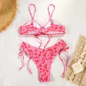 Close-up of pink floral bikini set with tie-side bottoms on a summer vacation background