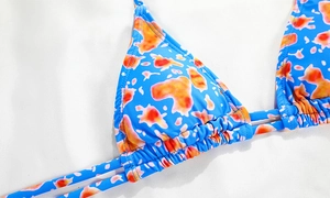Detail of sky blue triangle bikini top with vibrant orange ink splash print and stitching