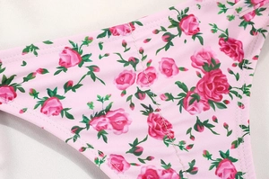 Detailed macro view of pink rose floral print fabric and high-quality stitching on bikini