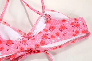 Detail of floral print bikini top with adjustable straps and silver metal buckles