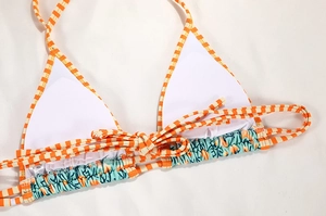 Detail of bikini top with orange stripes, teal print, soft padding and size S label