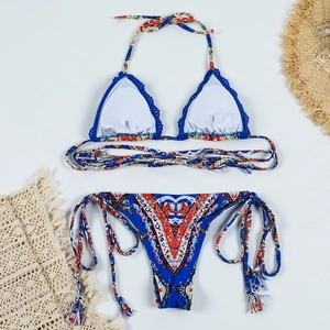 Vue à plat d'un bikini floral bohème avec bordure au crochet bleu et bas à nouer