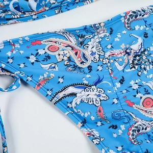 Close-up of blue paisley bikini bottom featuring adjustable side tie details
