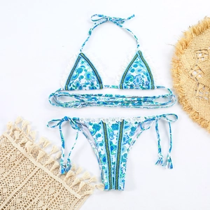 Two-piece paisley print bikini set with white lace trim and colorful braided tie straps
