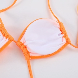Detailansicht des orangefarbenen Bikini-Oberteils mit weißer Polsterung und Faltennähten