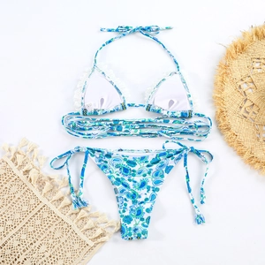 Detail of paisley print bikini with white lace trim and vacation beach accessories
