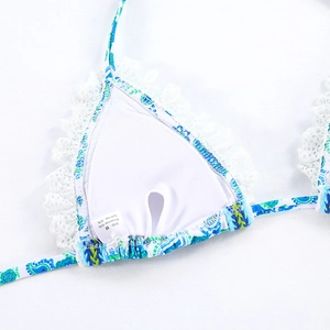 Detail of paisley print bikini top with white lace trim and M size care label