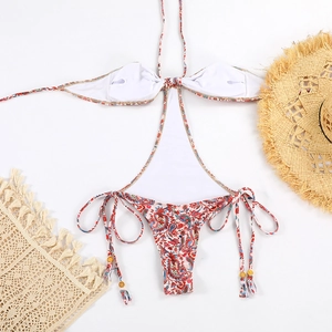 Close-up of paisley monokini with halter neck ties and decorative wooden bead fringe details