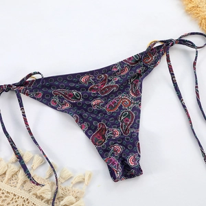 Detail der Paisley-Bikinihose mit seitlichen Bindebändern und goldenen Metallringen