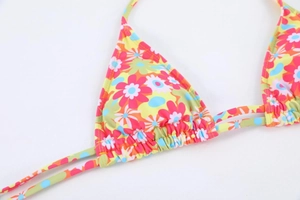Close-up of floral print bikini top featuring triangle cups and ruched details