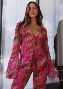 Detail of V-neck tie-front long sleeve top and pants in vibrant abstract ikat print