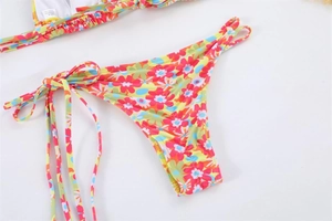 Detailed close-up of side-tie bikini bottoms with vibrant tropical floral prints
