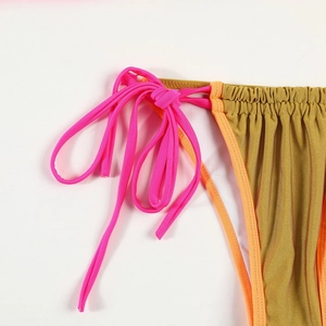 Detail of metallic gold bikini fabric with neon pink and orange tie-up straps