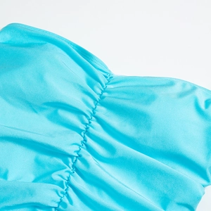 Détail du tissu froncé turquoise avec cordon de serrage montrant la texture lisse
