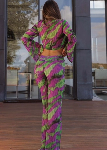 Back view of women's two-piece set featuring purple abstract print and flared pants