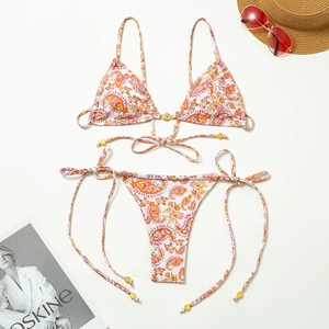 Detail of paisley print bikini set with metal accents and summer holiday accessories