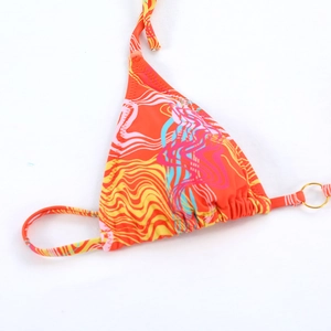 Detail of bohemian wave print bikini top featuring a golden metal ring and halter ties