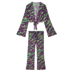 Detail view of the tie-front long sleeve crop top and high-waist pants set in purple abstract print
