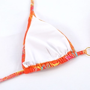 Detail of multi-color printed bikini top showing white lining and fabric care label
