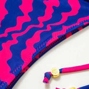 Detail of pink and blue wave pattern bikini with zigzag stitching and crown bead