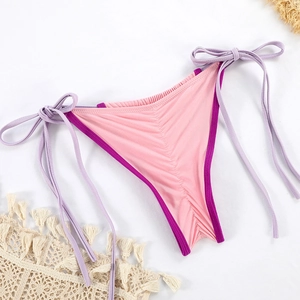 Detail of pink bikini bottom with purple side-tie strings and vertical ribbed texture