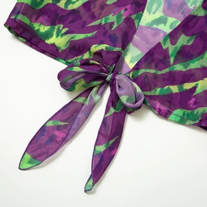 Detail of the front tie-up bow on a purple and green tie-dye mesh chiffon beach top