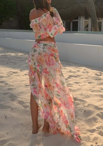 Detail of floral ruffle crop top and matching wrap skirt set against a sunny beach background