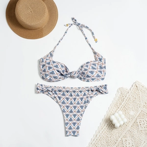 Flat lay di bikini a fascia con motivo geometrico blu retrò e accessori per le vacanze estive