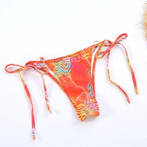 Detail of printed bikini bottoms with side ties and decorative gold metal rings