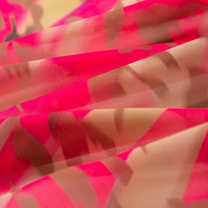 Macro detail of breathable pink floral mesh fabric with a lightweight semi-transparent texture