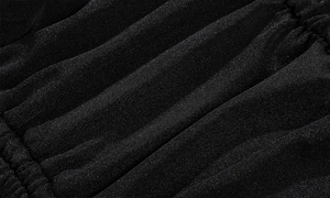 Gros plan détaillé montrant la texture plissée et le tissu fin de ce maillot de bain noir