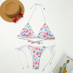 Bikini a fiori con bordo in pizzo bianco e puntali in metallo dorato sui lacci estivi
