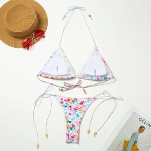 Vista piatta di bikini floreale con pizzo, cappello da sole e occhiali da sole per la spiaggia