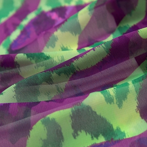Detailed macro view of lightweight sheer chiffon fabric with purple and green ink print