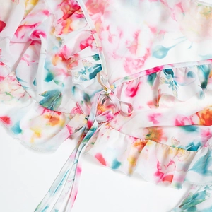 Detail of floral chiffon tie-front top with ruffles and feminine deep V-neckline