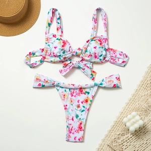 Flat lay view of a colorful floral bikini set with tie-knot top and high-cut bottom