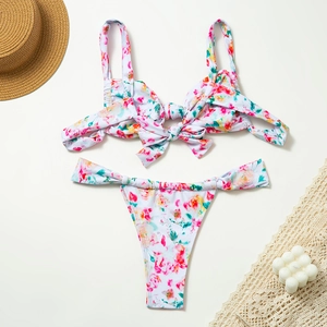 Flat lay of floral bikini with wide pleated straps and decorative knot details for summer