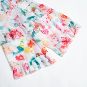 Close-up of multilayered ruffle edges with watercolor floral patterns on chiffon fabric