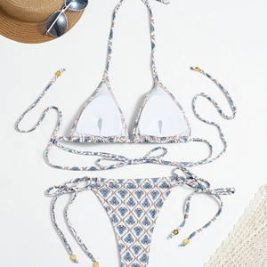 Detailed flat lay of bohemian plaid print bikini with lace decor and straw hat