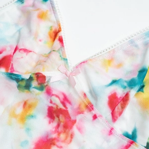 Detail of floral mesh top featuring white lace trim and a small pink ribbon bow detail