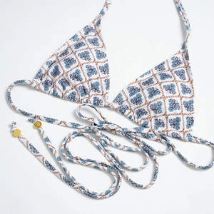 Detail of plaid bikini top featuring blue floral prints and gold crown beads on ties