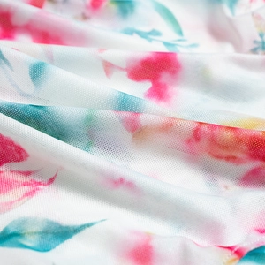 Detailed macro view of floral mesh fabric with pink and blue watercolor print and soft texture