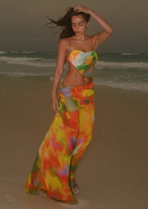 Détail d'un ensemble de plage dégradé coloré avec haut court et jupe portefeuille au coucher du soleil
