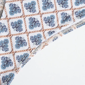 Close-up of checkered print fabric with brown chains and blue flower clusters on white base