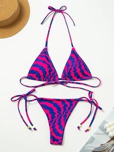 Two-piece striped bikini set with abstract wavy print and golden beaded side ties
