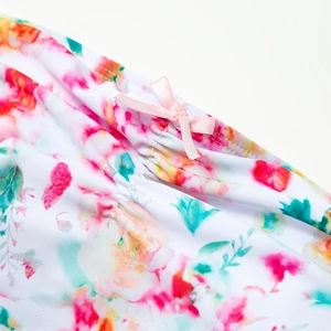 Close-up of floral print swimwear with pink ribbon bow and ruffled fabric texture