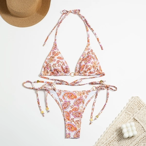 Flat lay of paisley print bikini set with side ties and golden ring hardware details