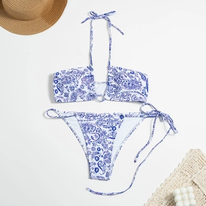 Flat lay of blue paisley bikini set with tie-up halter top and side-tie bottoms